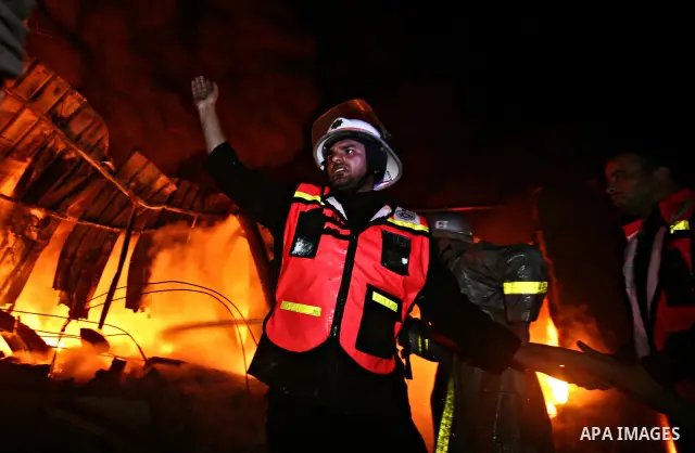 Palestinian fire fighters try to extinguish a blaze at a burning factory after an Israeli missile strike in the east of Gaza Strip on 14 March 2012. A fragile truce appeared to be taking hold between Israel and Palestini...