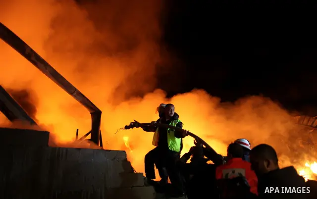 Palestinian fire fighters try to extinguish a blaze at a burning factory after an Israeli missile strike in the east of Gaza Strip on 14 March 2012. A fragile truce appeared to be taking hold between Israel and Palestini...