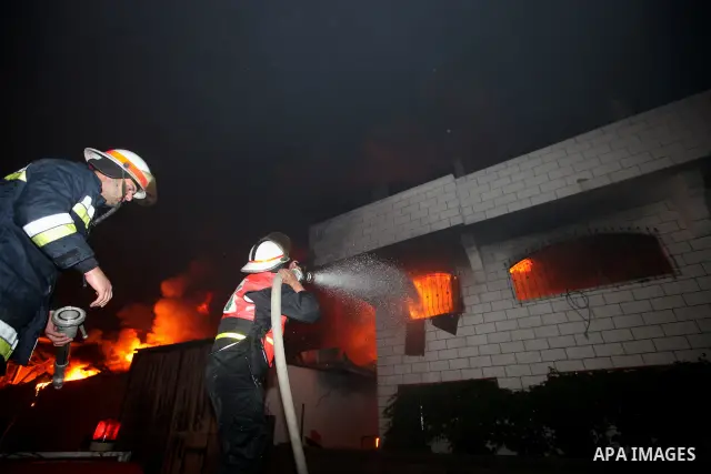 Palestinian fire fighters try to extinguish a blaze at a burning factory after an Israeli missile strike in the east of Gaza Strip on 14 March 2012. A fragile truce appeared to be taking hold between Israel and Palestini...