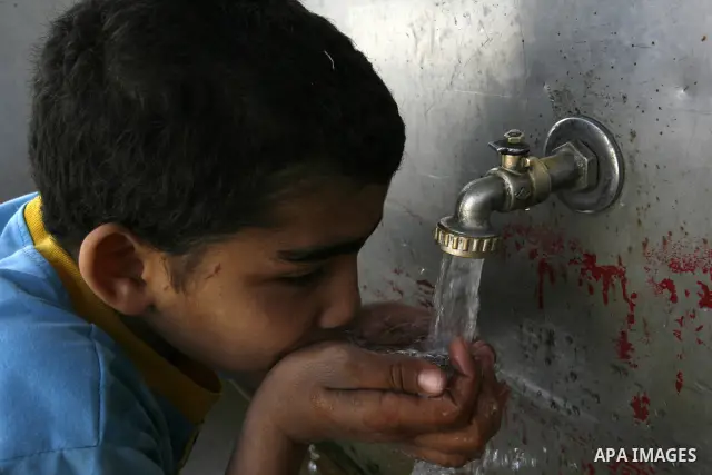 A Palestinian child drinks the water from tap at the United Nations Relief and Works Agency (UNRWA) headquarters in the southern Gaza Strip refugee camp of Rafah on March 14, 2012. The Palestinian Authority pushed plans...
