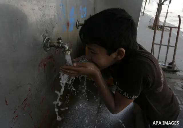 A Palestinian child drinks the water from tap at the United Nations Relief and Works Agency (UNRWA) headquarters in the southern Gaza Strip refugee camp of Rafah on March 14, 2012. The Palestinian Authority pushed plans...