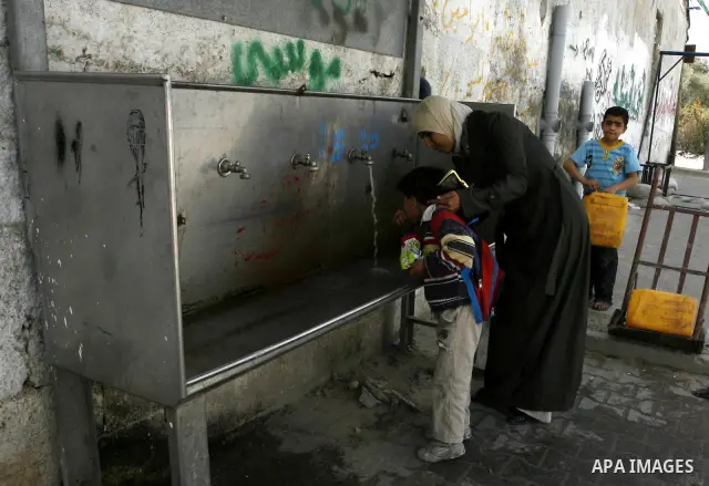 A Palestinian child drinks the water from tap at the United Nations Relief and Works Agency (UNRWA) headquarters in the southern Gaza Strip refugee camp of Rafah on March 14, 2012. The Palestinian Authority pushed plans...