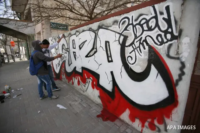 Palestinian students paint graffiti depicting word "Gaza" to show their support for the Gaza Strip and against Israeli air strikes, in the West Bank city of Hebron, on March 15, 2012. Photo by Mamoun Wazwaz.
