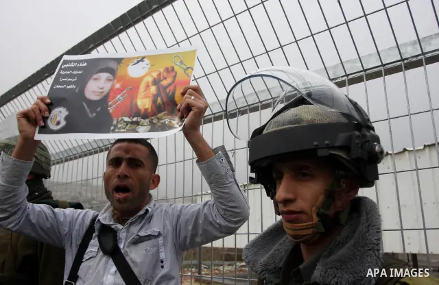 Palestinian protestors clash with Israeli soldiers at the entrance to Ofer Prison near Ramallah in the Occupied West Bank during a demonstration to support female prisoner Hanaa al-Shalabi (portrait) who was freed in a p...