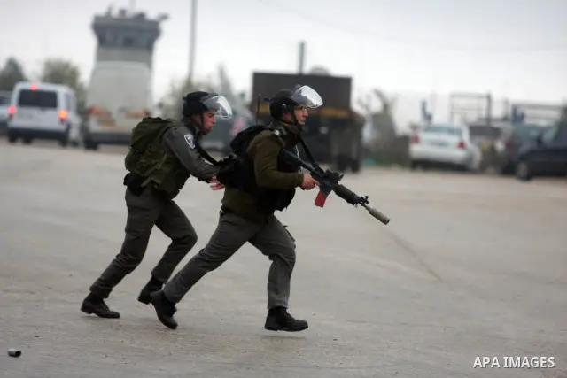 Palestinian protestors clash with Israeli soldiers at the entrance to Ofer Prison near Ramallah in the Occupied West Bank during a demonstration to support female prisoner Hanaa al-Shalabi (portrait) who was freed in a p...