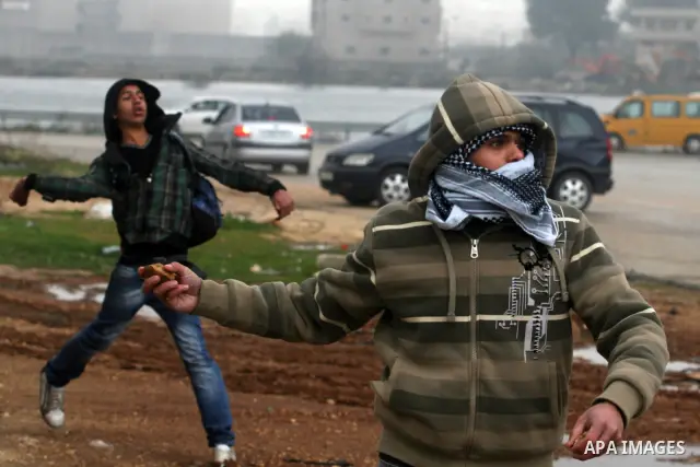 Palestinian protestors clash with Israeli soldiers at the entrance to Ofer Prison near Ramallah in the Occupied West Bank during a demonstration to support female prisoner Hanaa al-Shalabi (portrait) who was freed in a p...