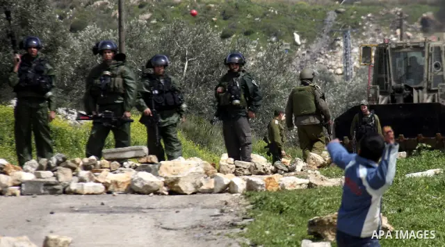 Palestinian youths hurl stones at Israeli security forces ,during a protest in the village of Kufr Qaddum near the Israeli settlement of Kdumim, in the northern West Bank, Friday,March 16, 2012. Photo by Wagdi Eshtayah