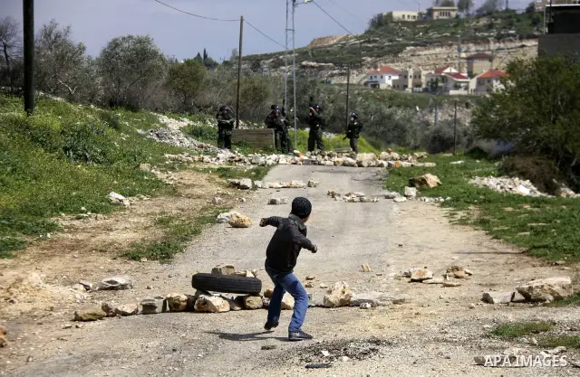 Palestinian youths hurl stones at Israeli security forces ,during a protest in the village of Kufr Qaddum near the Israeli settlement of Kdumim, in the northern West Bank, Friday,March 16, 2012. Photo by Wagdi Eshtayah
