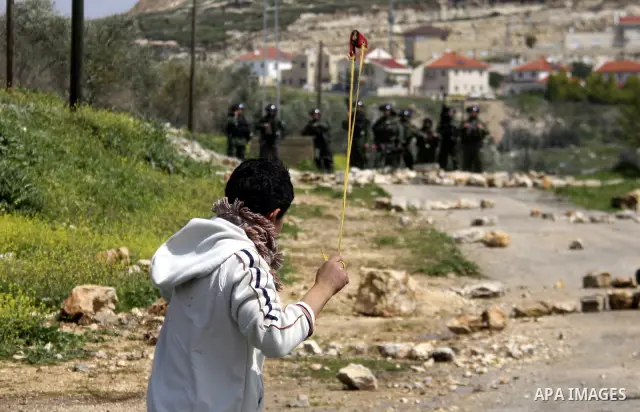 Palestinian youths hurl stones at Israeli security forces ,during a protest in the village of Kufr Qaddum near the Israeli settlement of Kdumim, in the northern West Bank, Friday,March 16, 2012. Photo by Wagdi Eshtayah