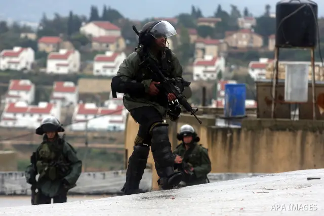 Israeli soldiers march during clashes with Palestinian and foreign activists in the West Bank village of Nabi Saleh, near Ramallah, on March 16, 2012 following a protest against Palestinian land confiscation to build the...