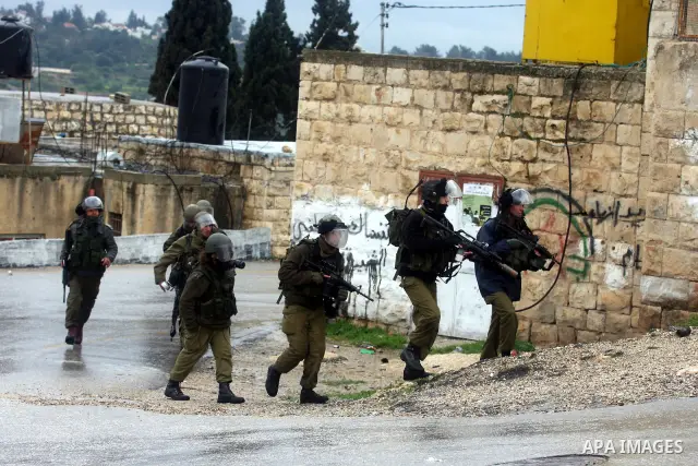 Israeli soldiers march during clashes with Palestinian and foreign activists in the West Bank village of Nabi Saleh, near Ramallah, on March 16, 2012 following a protest against Palestinian land confiscation to build the...