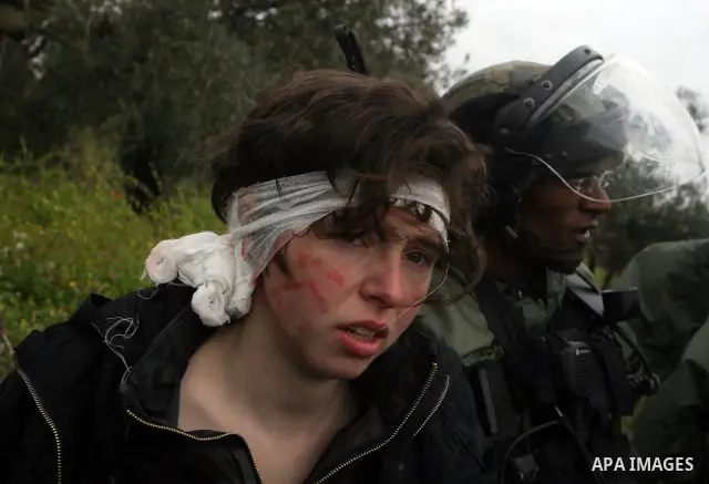 Naomi Laet, 22, an Israeli pro-Palestinian activist, is treated by Israeli security force officers after she sustained a head injury from a rubber bullet fired by the forces during clashes with Palestinian stone-throwers...