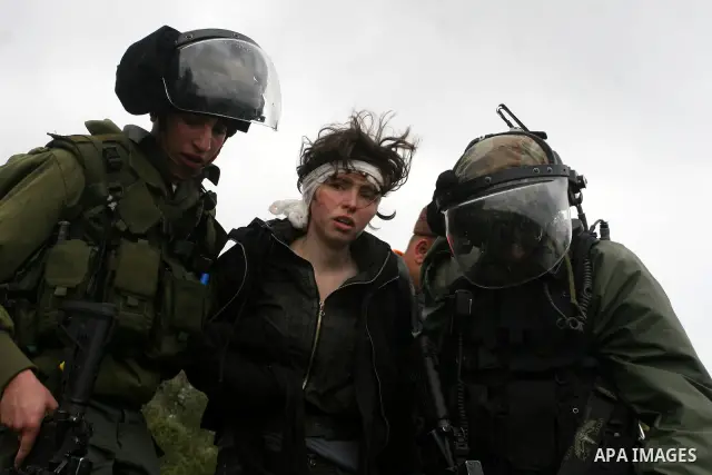 Naomi Laet, 22, an Israeli pro-Palestinian activist, is treated by Israeli security force officers after she sustained a head injury from a rubber bullet fired by the forces during clashes with Palestinian stone-throwers...
