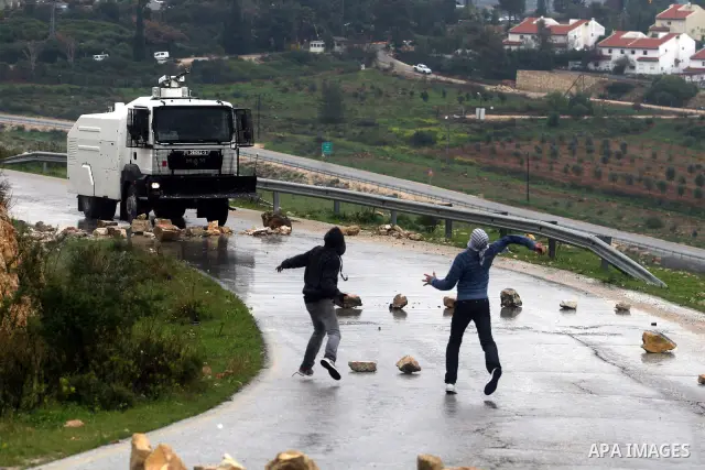 A Palestinian protester hurls a stone at Israeli soldiers during a protest in the West Bank village of Nabi Saleh, near Ramallah, on March 16, 2012 against the confiscation of Palestinian land to build the Jewish settlem...