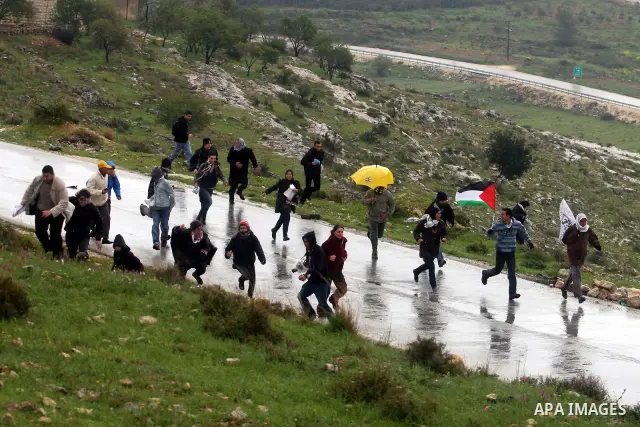 A Palestinian protester hurls a stone at Israeli soldiers during a protest in the West Bank village of Nabi Saleh, near Ramallah, on March 16, 2012 against the confiscation of Palestinian land to build the Jewish settlem...