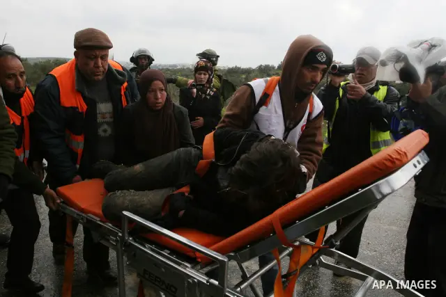 Naomi Laet, 22, an Israeli pro-Palestinian activist, is treated by Israeli security force officers after she sustained a head injury from a rubber bullet fired by the forces during clashes with Palestinian stone-throwers...