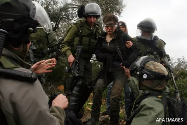 Naomi Laet, 22, an Israeli pro-Palestinian activist, is treated by Israeli security force officers after she sustained a head injury from a rubber bullet fired by the forces during clashes with Palestinian stone-throwers...