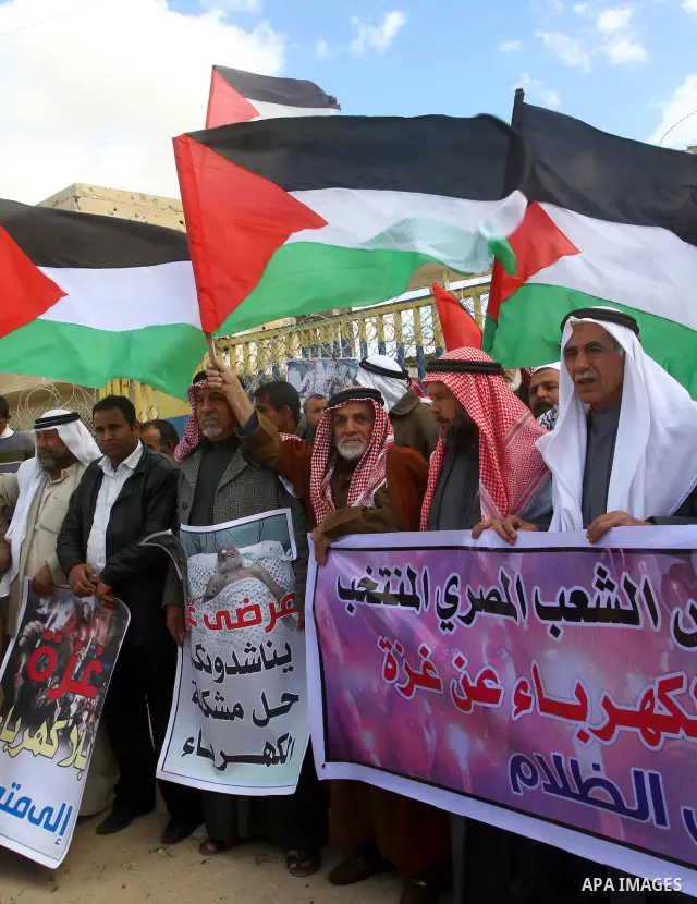 Palestinians attend a rally in front of the Rafah border crossing with Egypt on March 17, 2012, during a sit-in Rafah demanding Egypt provide the Gaza Strip with electricity and diesel. The Palestinian energy authority i...
