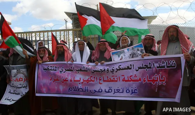 Palestinians attend a rally in front of the Rafah border crossing with Egypt on March 17, 2012, during a sit-in Rafah demanding Egypt provide the Gaza Strip with electricity and diesel. The Palestinian energy authority i...