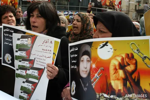 Palestinian women hold portraits of jailed compatriot Hana Shalabi, a female Palestinian prisoner jailed in Israel who has been on hunger strike for 26 days, outside the Red Cross building in the West Bank city of Hebron...