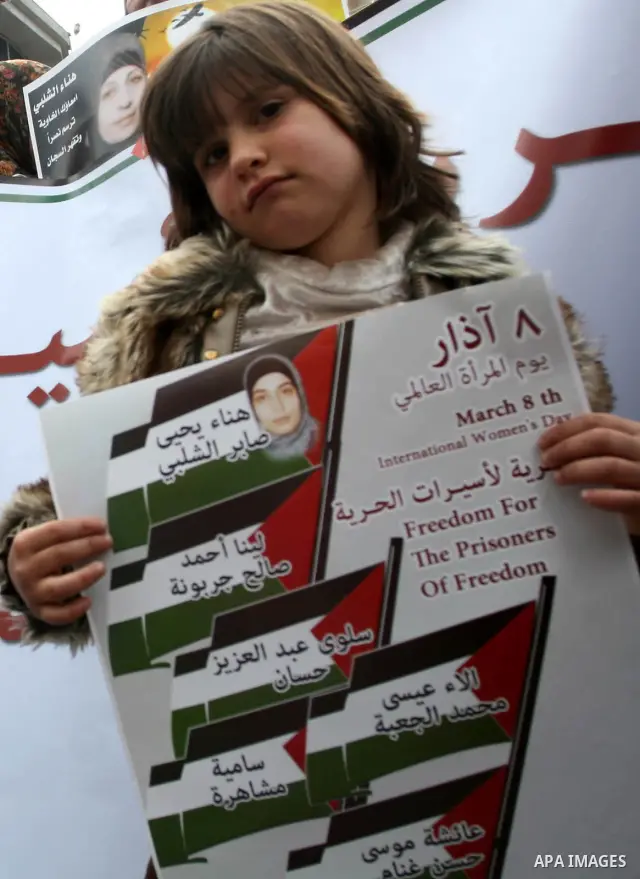 Palestinian children hold portraits of jailed compatriot Hana Shalabi, a female Palestinian prisoner jailed in Israel who has been on hunger strike for 26 days, outside the Red Cross building in the West Bank city of Heb...