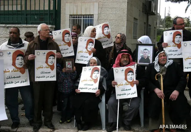 Palestinians hold portraits of jailed compatriot Hana Shalabi, a female Palestinian prisoner jailed in Israel who has been on hunger strike for 31 days, in Jerusalem, 17 March 2012. Palestinian sources said that Shalabi...