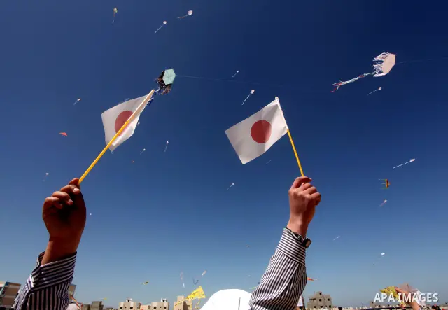 Palestinian children fly kites to show their solidarity with the Japanese people near a Japanese-funded housing project in Khan Younis in the southern Gaza Strip March 18, 2012. The event was organized by the United Nati...