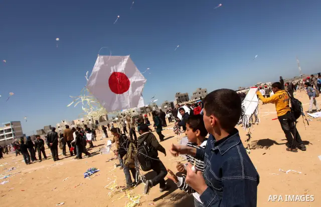 Palestinian children fly kites to show their solidarity with the Japanese people near a Japanese-funded housing project in Khan Younis in the southern Gaza Strip March 18, 2012. The event was organized by the United Nati...