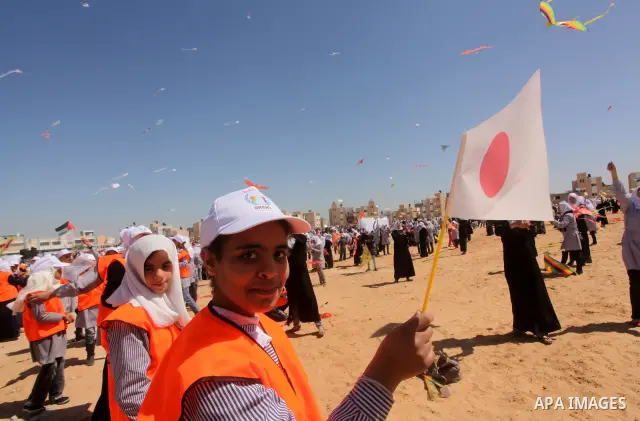 Palestinian children fly kites to show their solidarity with the Japanese people near a Japanese-funded housing project in Khan Younis in the southern Gaza Strip March 18, 2012. The event was organized by the United Nati...