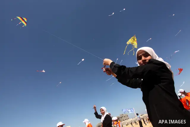 Palestinian children fly kites to show their solidarity with the Japanese people near a Japanese-funded housing project in Khan Younis in the southern Gaza Strip March 18, 2012. The event was organized by the United Nati...