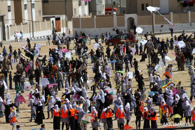 Palestinian children fly kites to show their solidarity with the Japanese people near a Japanese-funded housing project in Khan Younis in the southern Gaza Strip March 18, 2012. The event was organized by the United Nati...