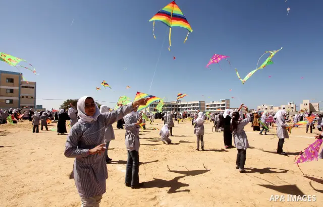 Palestinian children fly kites to show their solidarity with the Japanese people near a Japanese-funded housing project in Khan Younis in the southern Gaza Strip March 18, 2012. The event was organized by the United Nati...