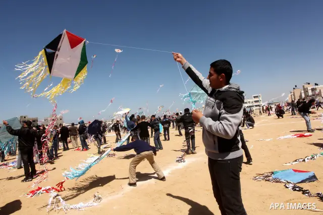 Palestinian children fly kites to show their solidarity with the Japanese people near a Japanese-funded housing project in Khan Younis in the southern Gaza Strip March 18, 2012. The event was organized by the United Nati...
