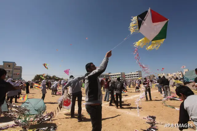 Palestinian children fly kites to show their solidarity with the Japanese people near a Japanese-funded housing project in Khan Younis in the southern Gaza Strip March 18, 2012. The event was organized by the United Nati...
