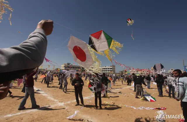 Palestinian children fly kites to show their solidarity with the Japanese people near a Japanese-funded housing project in Khan Younis in the southern Gaza Strip March 18, 2012. The event was organized by the United Nati...