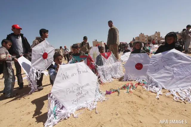 Palestinian children fly kites to show their solidarity with the Japanese people near a Japanese-funded housing project in Khan Younis in the southern Gaza Strip March 18, 2012. The event was organized by the United Nati...