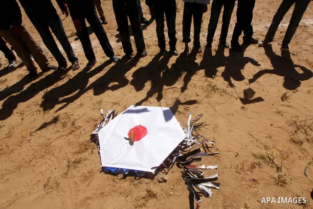 Palestinian children fly kites to show their solidarity with the Japanese people near a Japanese-funded housing project in Khan Younis in the southern Gaza Strip March 18, 2012. The event was organized by the United Nati...