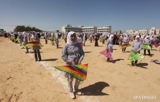 Palestinian children fly kites to show their solidarity with the Japanese people near a Japanese-funded housing project in Khan Younis in the southern Gaza Strip March 18, 2012. The event was organized by the United Nati...
