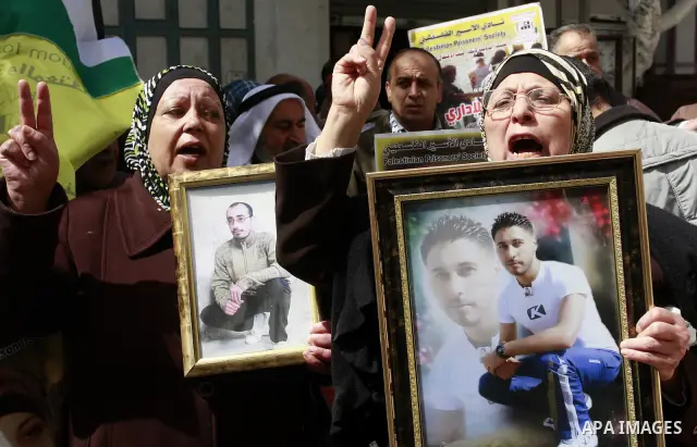 Palestinian women hold portraits of jailed compatriot Hana Shalabi, a female Palestinian prisoner jailed in Israel who has been on hunger strike for 33 days, outside the Red Cross building in the West Bank city of Nablus...