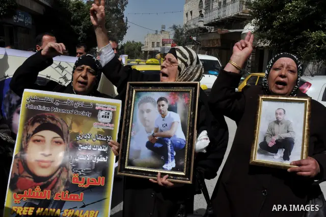 Palestinian women hold portraits of jailed compatriot Hana Shalabi, a female Palestinian prisoner jailed in Israel who has been on hunger strike for 33 days, outside the Red Cross building in the West Bank city of Nablus...