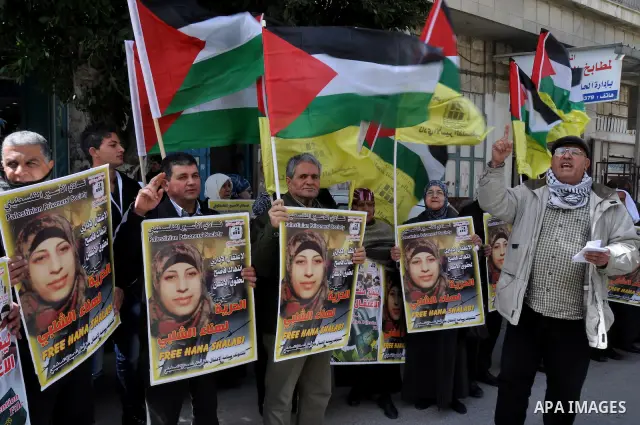 Palestinian women hold portraits of jailed compatriot Hana Shalabi, a female Palestinian prisoner jailed in Israel who has been on hunger strike for 33 days, outside the Red Cross building in the West Bank city of Nablus...