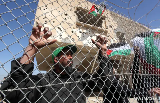 Palestinian demonstrators wave national flags during a protest in the Rafah border crossing with Egypt on March 19, 2012, demanding Egypt provide the Gaza Strip with electricity and fuel. The Palestinian energy authority...