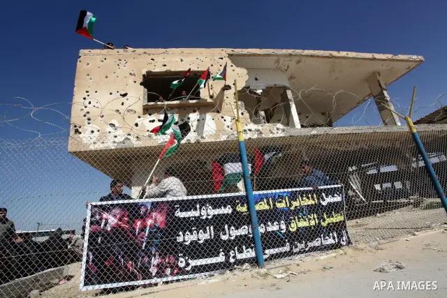 Palestinian demonstrators wave national flags during a protest in the Rafah border crossing with Egypt on March 19, 2012, demanding Egypt provide the Gaza Strip with electricity and fuel. The Palestinian energy authority...