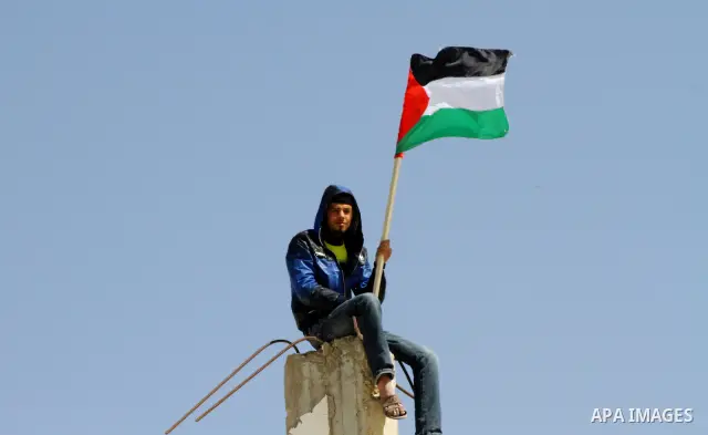 Palestinian demonstrators wave national flags during a protest in the Rafah border crossing with Egypt on March 19, 2012, demanding Egypt provide the Gaza Strip with electricity and fuel. The Palestinian energy authority...