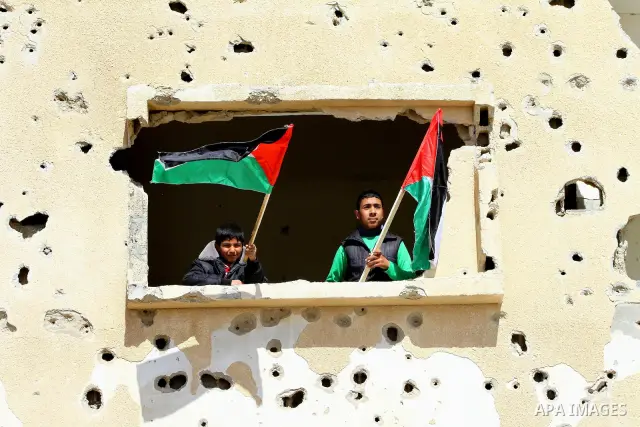 Palestinian demonstrators wave national flags during a protest in the Rafah border crossing with Egypt on March 19, 2012, demanding Egypt provide the Gaza Strip with electricity and fuel. The Palestinian energy authority...