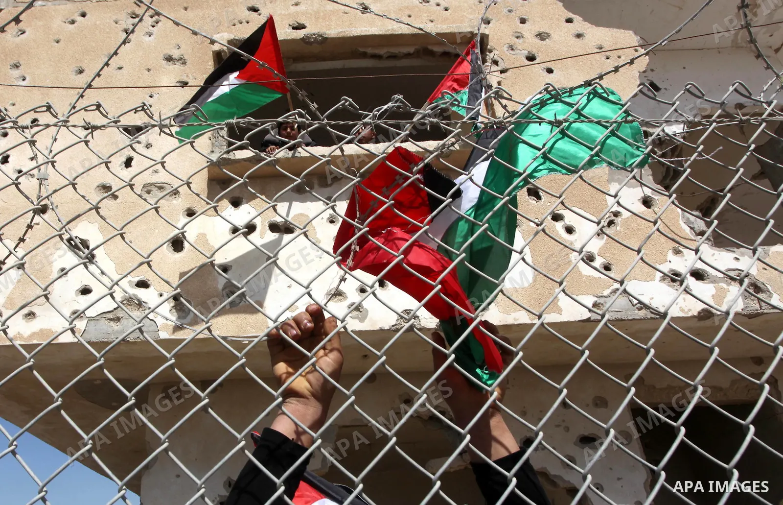 Palestinian demonstrators wave national flags during a protest in the Rafah border crossing with Egypt on March 19, 2012, demanding Egypt provide the Gaza Strip with electricity and fuel. The Palestinian energy authority...