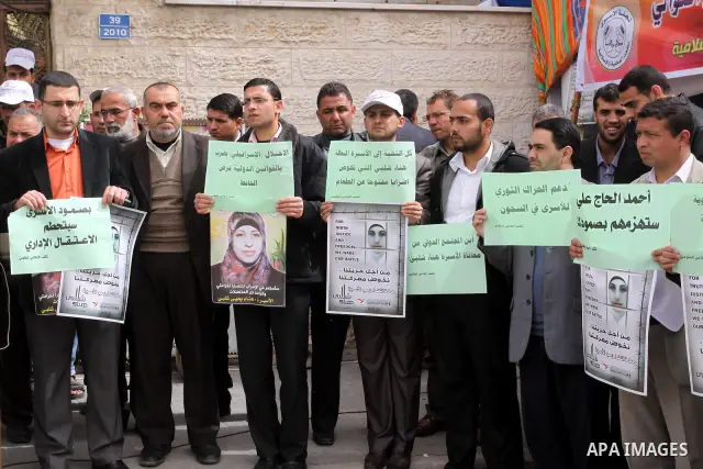 Palestinian employees of the information government office demonstrate in solidarity with Hana'a Shalabi, a female Palestinian prisoner jailed in Israel who has been on hunger strike for 34 days, outside the Red Cross bu...