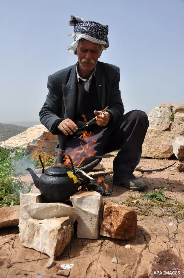 Palestinian shepherd Abu Jaafar makes a tea by a fire in Biet Leed village near the West Bank city of Tulkarem, 20 March 2012. Photo by Nedal Eshtayah