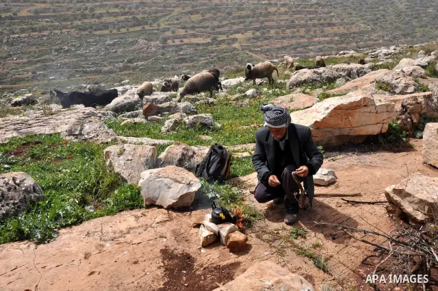 Palestinian shephered Abu Jaafar makes a tea by a fire in Biet Leed village near the west bank city of Tulkarem, 20 March 2012. Photo by Nedal Eshtayah