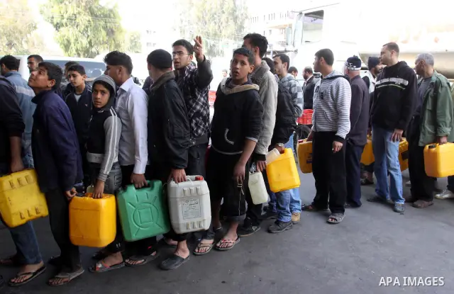 Palestinians fill containers with fuel from a petrol station in the Gaza City on 21 March 2012. Reports state that residents in the Gaza Strip flocked to petrol stations hoping to get a share of the remaining fuel, sayin...